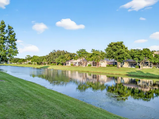 a view of a lake with a garden and swimming pool