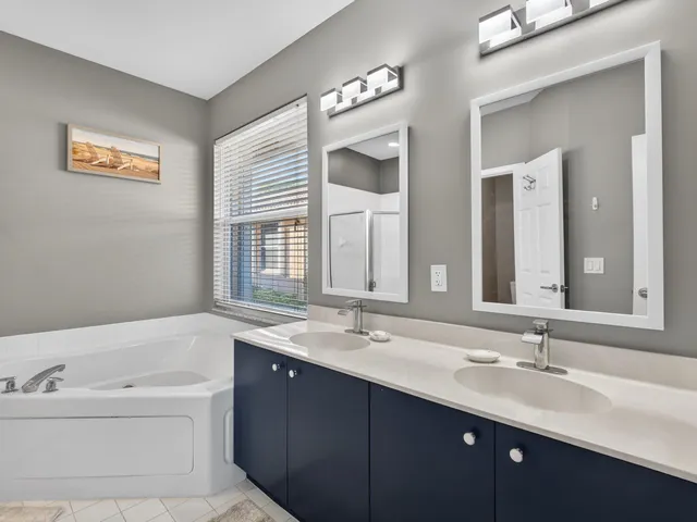 a bathroom with a tub a sink and mirror