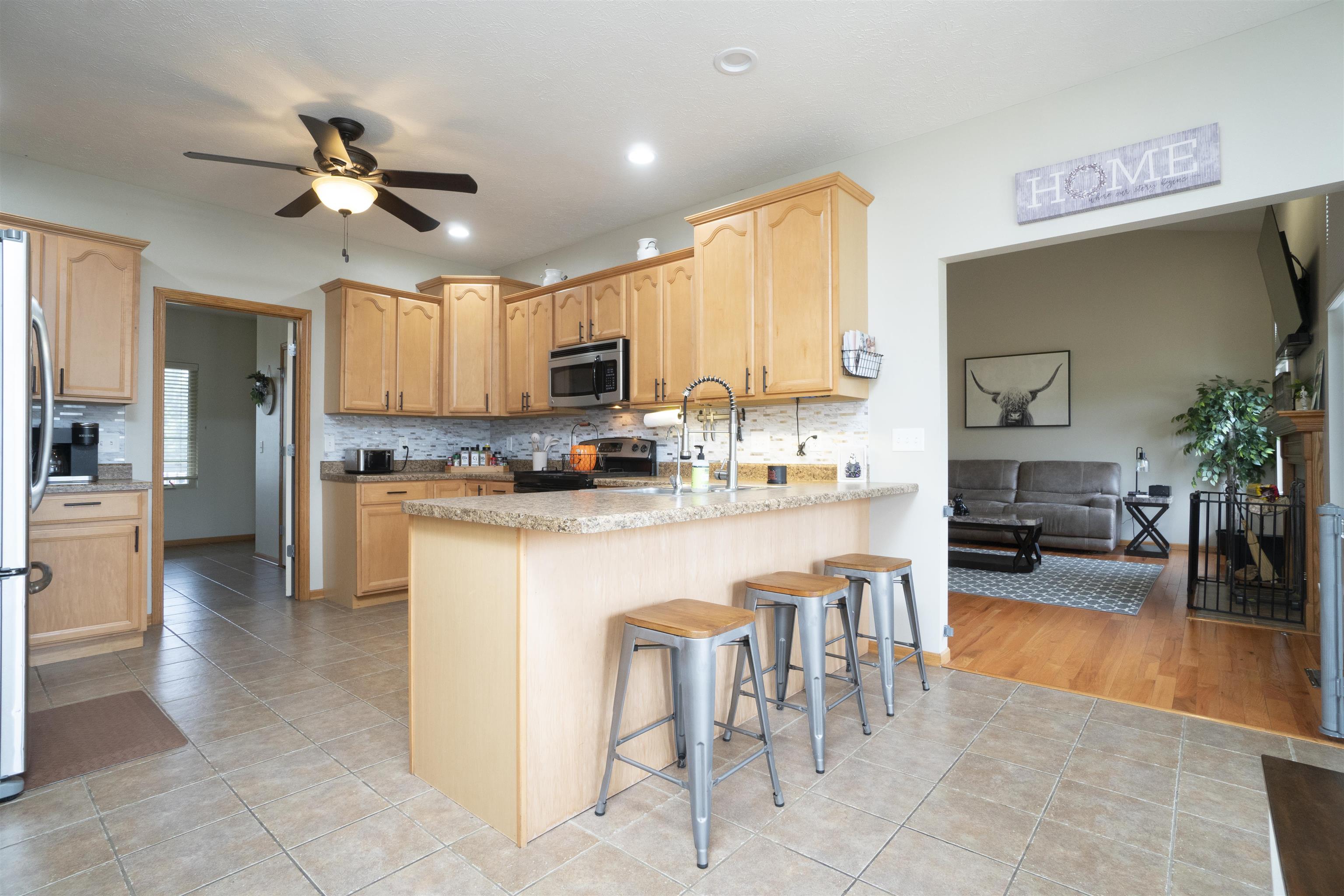 3271 North Silver Ridge Drive Oregon, IL 61061 - Photo 13 of 45 a kitchen with stainless steel appliances kitchen island granite countertop a refrigerator a stove top oven a sink dishwasher and white cabinets