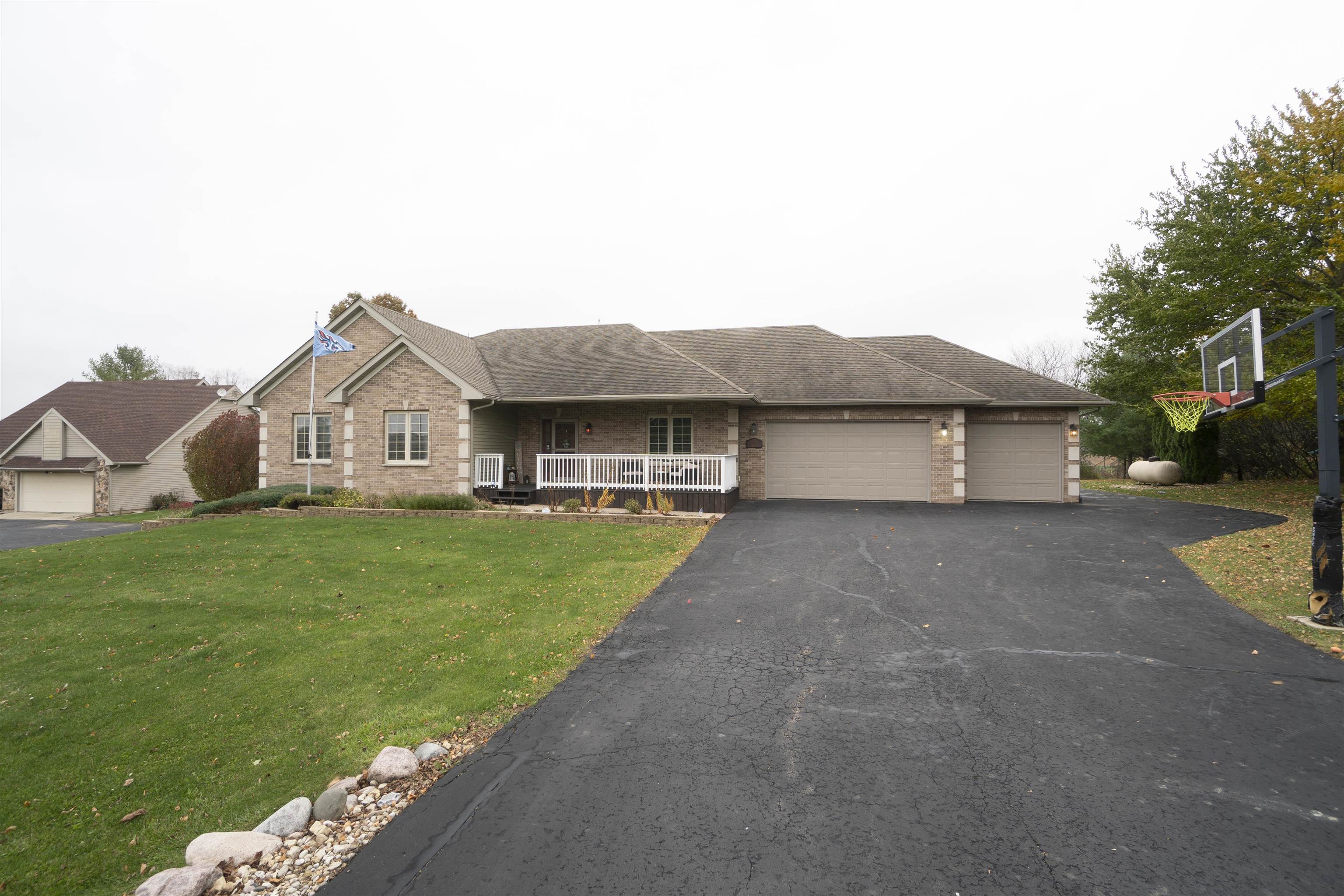 3271 North Silver Ridge Drive Oregon, IL 61061 - Photo 2 of 45 a front view of a house with a garden and yard