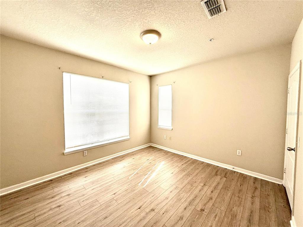8842 Villa View Circle, Unit 3 Orlando, FL 32821 - Photo 16 of 21 an empty room with wooden floor and windows