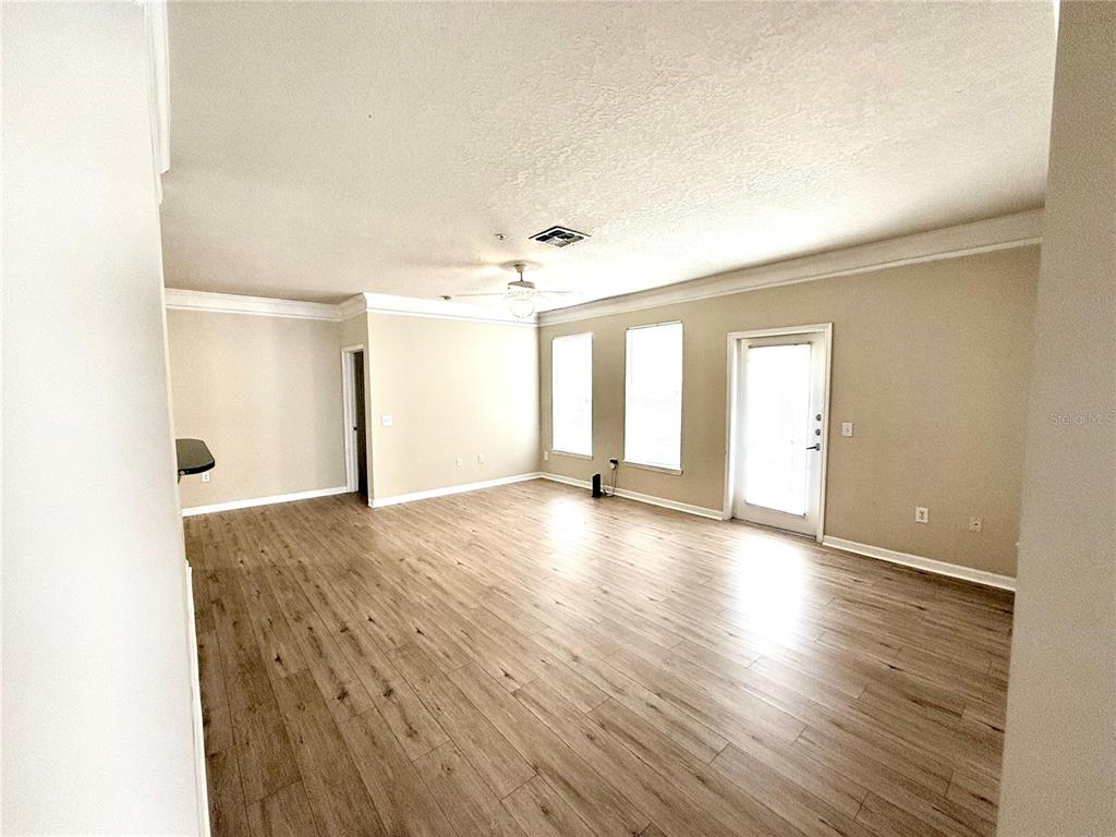 8842 Villa View Circle, Unit 3 Orlando, FL 32821 - Photo 19 of 21 a view of empty room with wooden floor and fan