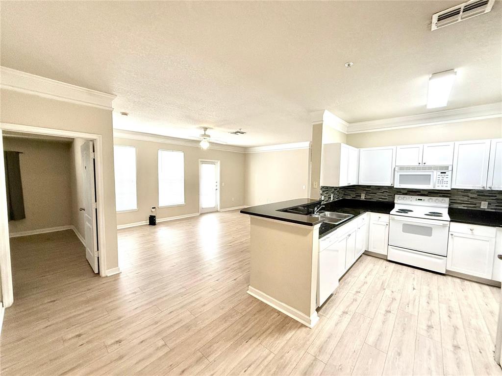 8842 Villa View Circle, Unit 3 Orlando, FL 32821 - Photo 20 of 21 a large white kitchen with wooden floor