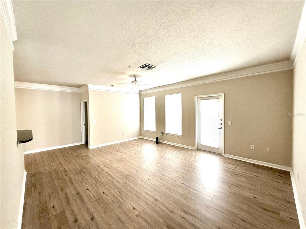 8842 Villa View Circle, Unit 3 Orlando, FL 32821 - Photo 21 of 21 a view of an empty room with wooden floor and a window