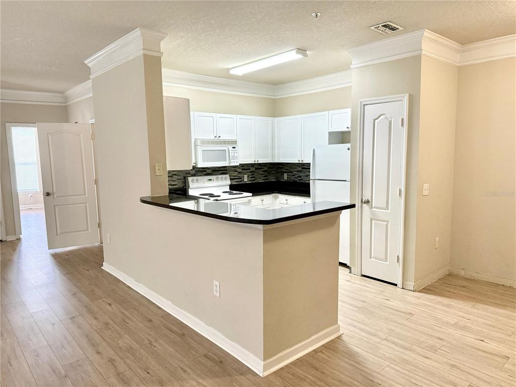 8842 Villa View Circle, Unit 3 Orlando, FL 32821 - Photo 3 of 21 a kitchen with stainless steel appliances granite countertop a refrigerator a sink and a stove