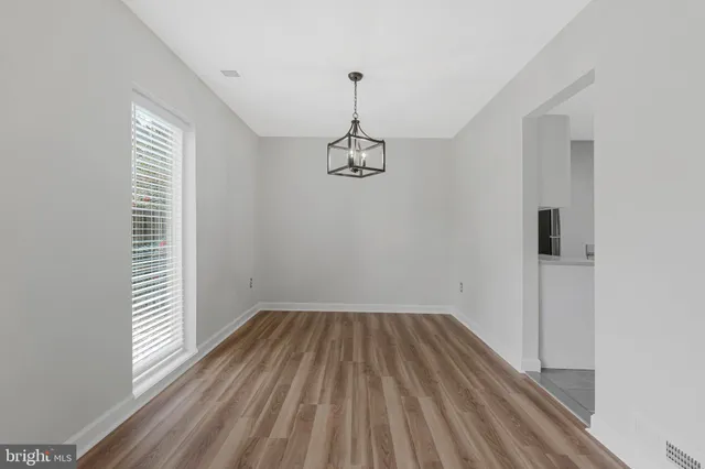 a view of a hallway with wooden floor and closet