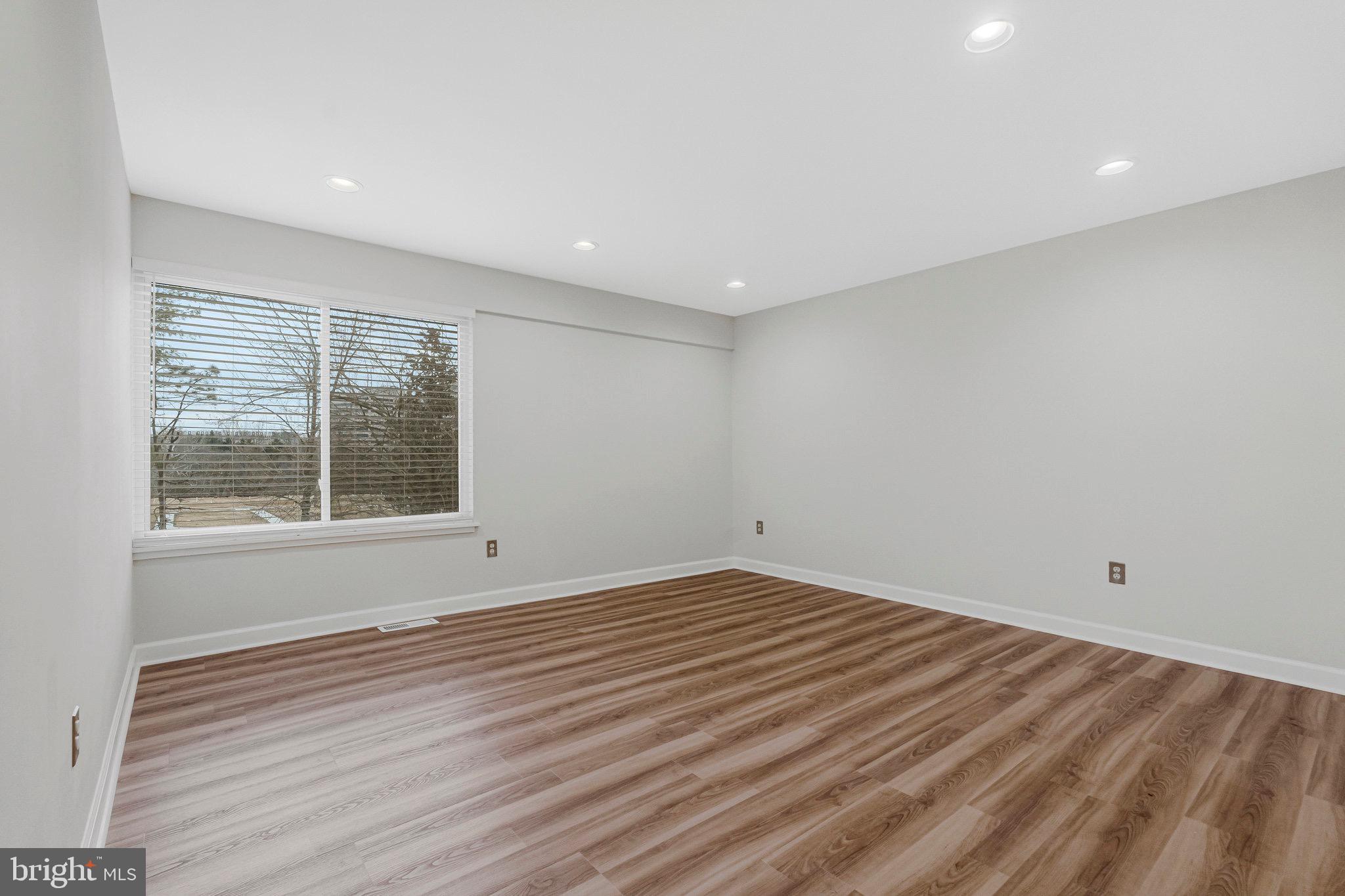 1801 Ivy Oak Square, Unit 65 Reston, VA 20190 - Photo 17 of 43 a view of an empty room with wooden floor and a window