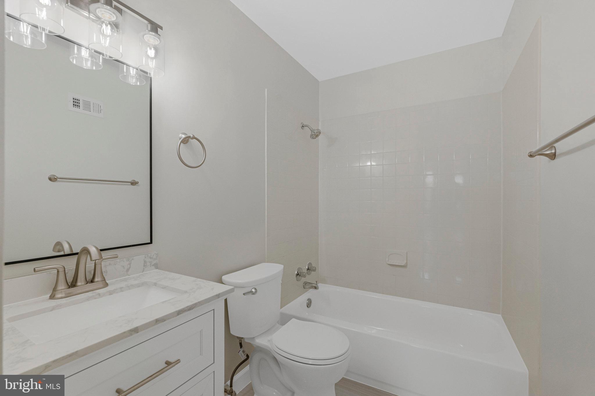 1801 Ivy Oak Square, Unit 65 Reston, VA 20190 - Photo 24 of 43 a bathroom with a granite countertop sink a toilet and shower