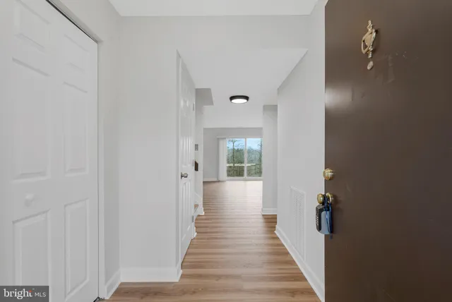 a view of a room with wooden floor and white walls