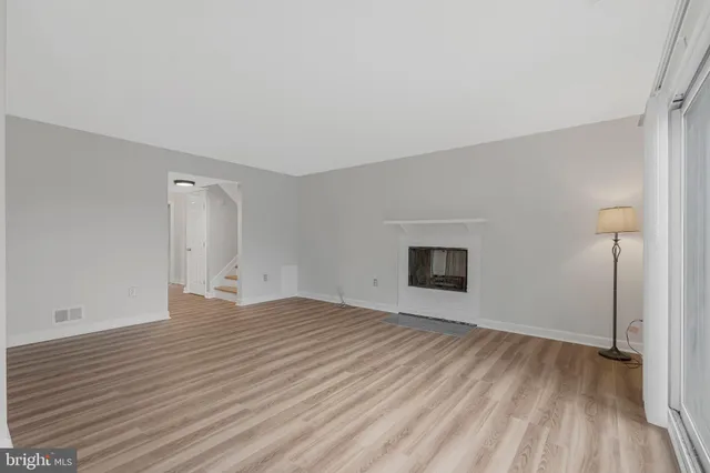a view of a room with wooden floor and white walls