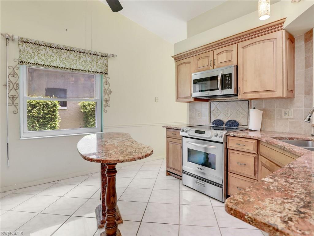 13243 Heather Ridge Loop Fort Myers, FL 33966 - Photo 11 of 34 a kitchen with stainless steel appliances granite countertop a sink a stove a microwave and cabinets