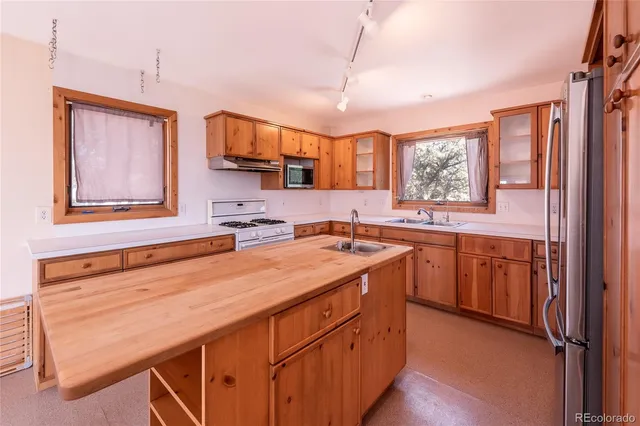 a kitchen with stainless steel appliances granite countertop a sink stove and wooden cabinets