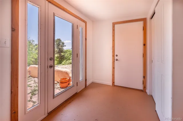 a view of empty room with wooden floor and door