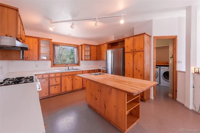 a large kitchen with stainless steel appliances granite countertop a stove a sink dishwasher and a refrigerator