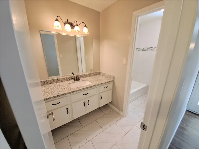 a bathroom with a granite countertop sink a mirror and a vanity