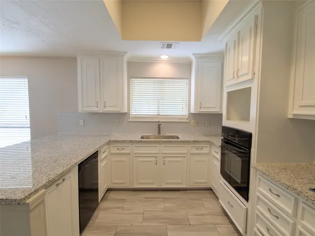 a kitchen with a sink stove and cabinets