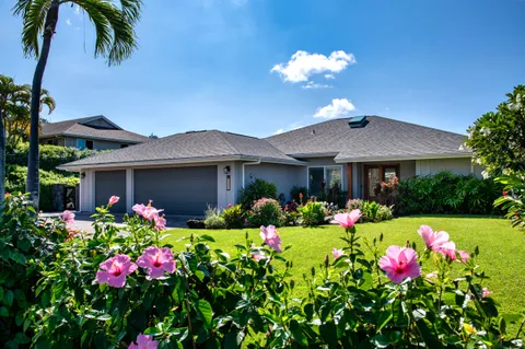 a front view of house and yard with beautiful flowers