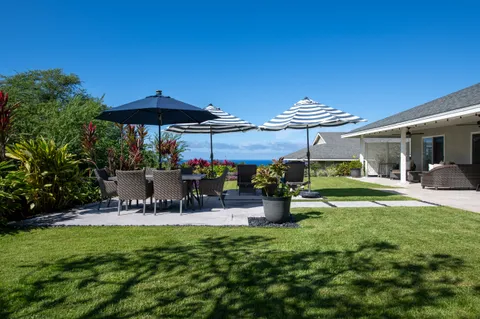 a view of a patio with table and chairs under an umbrella