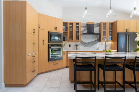 a kitchen with stainless steel appliances kitchen island granite countertop a refrigerator and cabinets