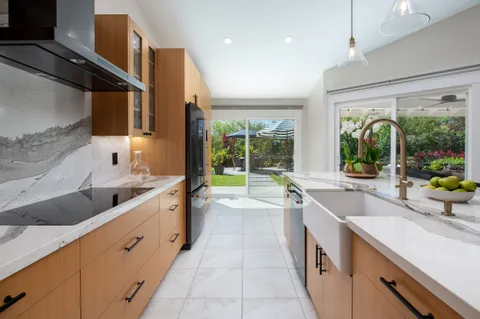 a large kitchen with stainless steel appliances granite countertop a sink and a large window