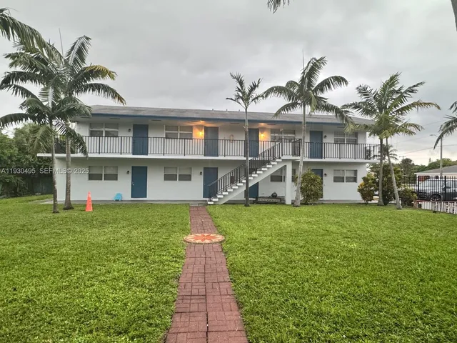 a front view of a house with a garden and yard