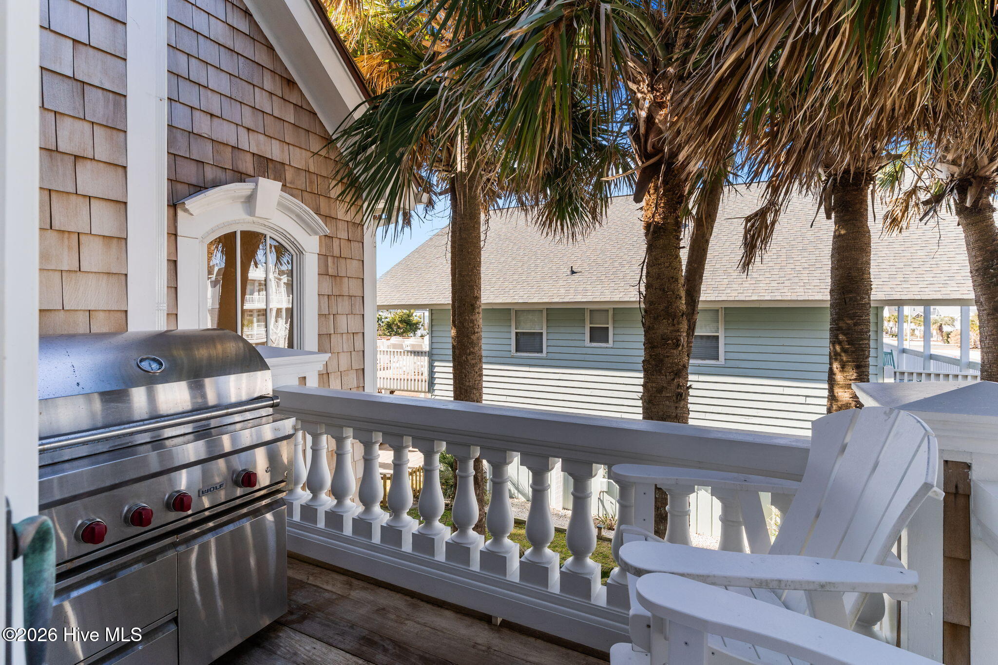 241 West First Street Ocean Isle Beach, NC 28469 - Photo 26 of 124 Grilling deck attached to kitchen/dining area. Notice beautiful cedar shake siding and mature landscaping.