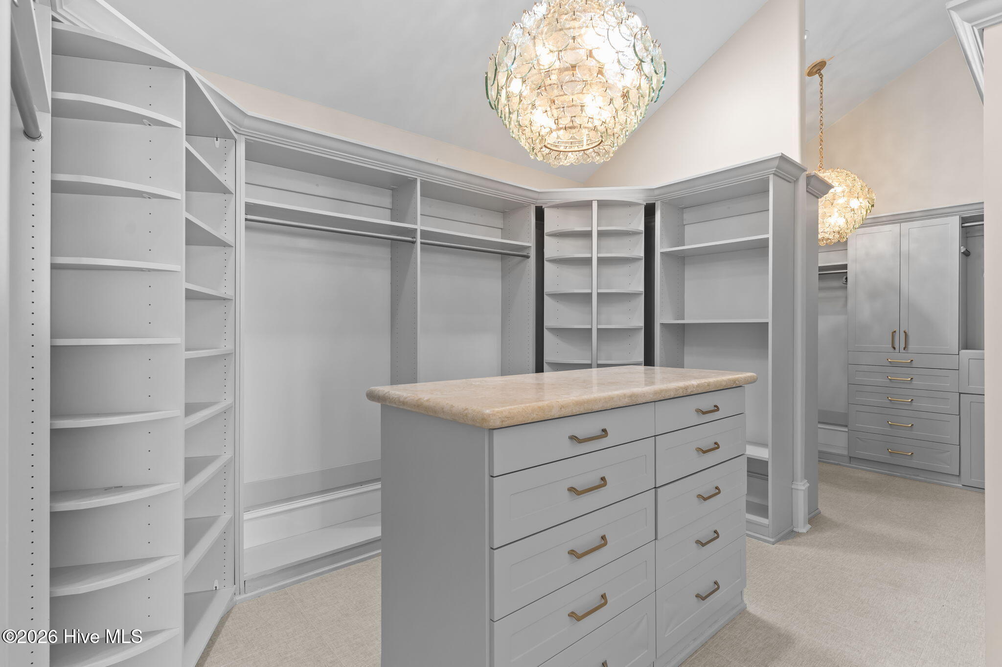 241 West First Street Ocean Isle Beach, NC 28469 - Photo 64 of 124 Primary bedroom walk-in closet with dressing table. Multiple chandeliers, closet system and access to elevator.