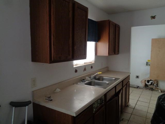 1500 5th Street Ralls, TX 79357 - Photo 4 of 10 a kitchen with a sink cabinets and black stainless steel appliances