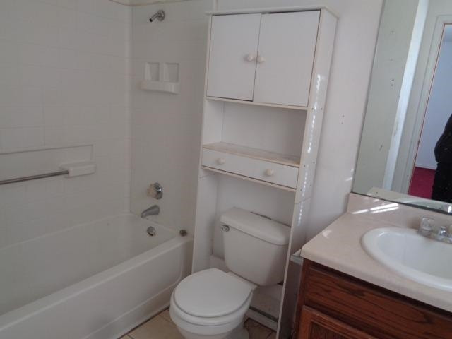1500 5th Street Ralls, TX 79357 - Photo 6 of 10 a bathroom with a sink a toilet and bathtub