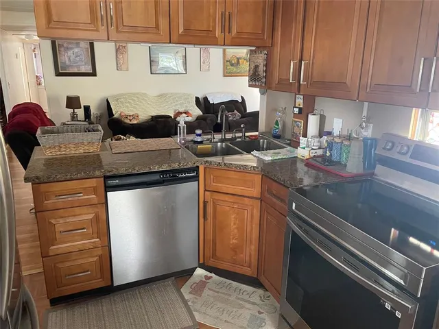 a kitchen with stainless steel appliances granite countertop a sink stove and cabinets