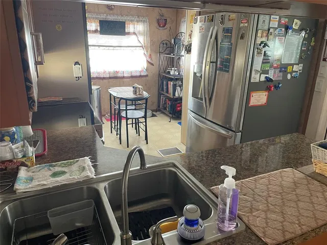 a kitchen with stainless steel appliances granite countertop a refrigerator and a sink