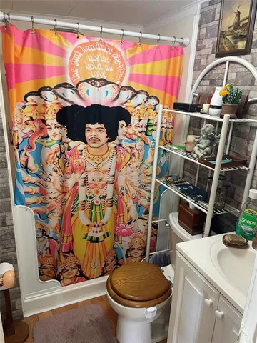 a bathroom with a sink toilet and shower curtain
