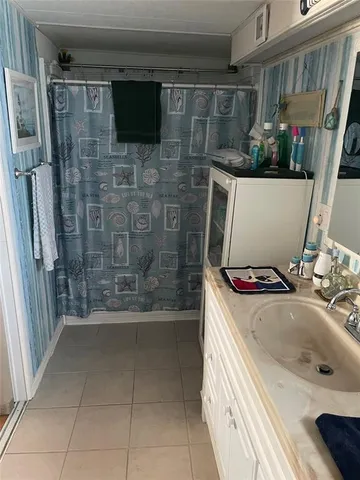 a bathroom with a sink a mirror and shower