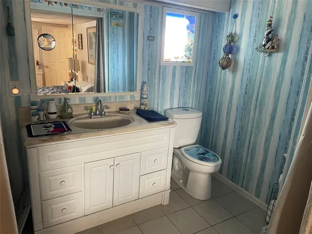 a bathroom with a granite countertop sink a toilet and a mirror
