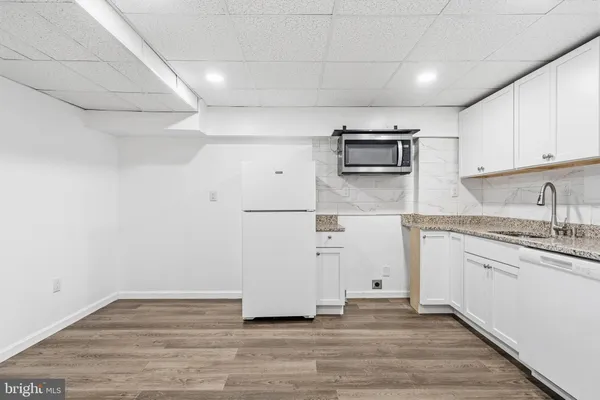 a view of a kitchen with a refrigerator and a stove top oven