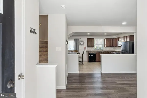 a large white kitchen with a refrigerator and a sink