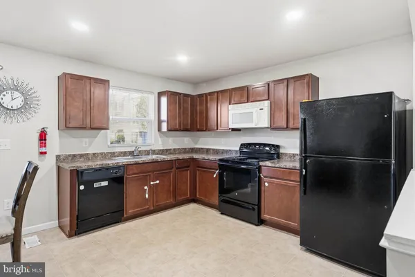 a kitchen with stainless steel appliances granite countertop a refrigerator stove and sink
