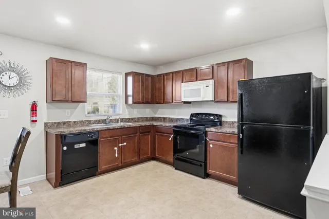 a kitchen with stainless steel appliances granite countertop a refrigerator stove and sink