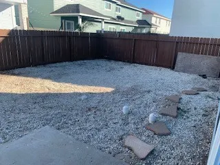 a view of backyard with wooden fence