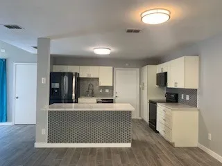 a kitchen with stainless steel appliances a sink a stove a refrigerator cabinets and a dining table