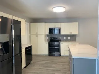 a kitchen with a refrigerator and a stove top oven