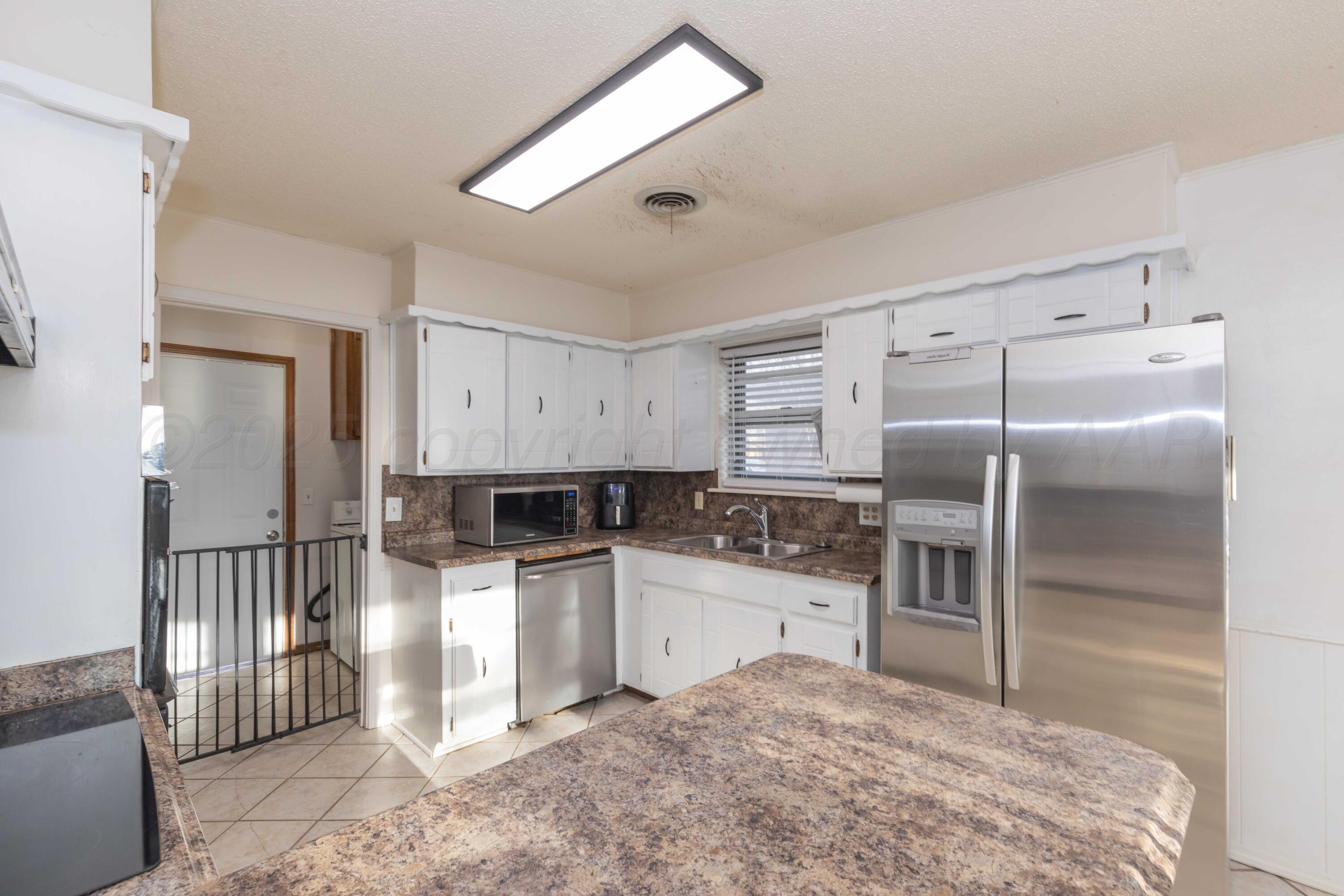 5301 Leigh Avenue Amarillo, TX 79110 - Photo 11 of 35 a kitchen with granite countertop a refrigerator and a stove
