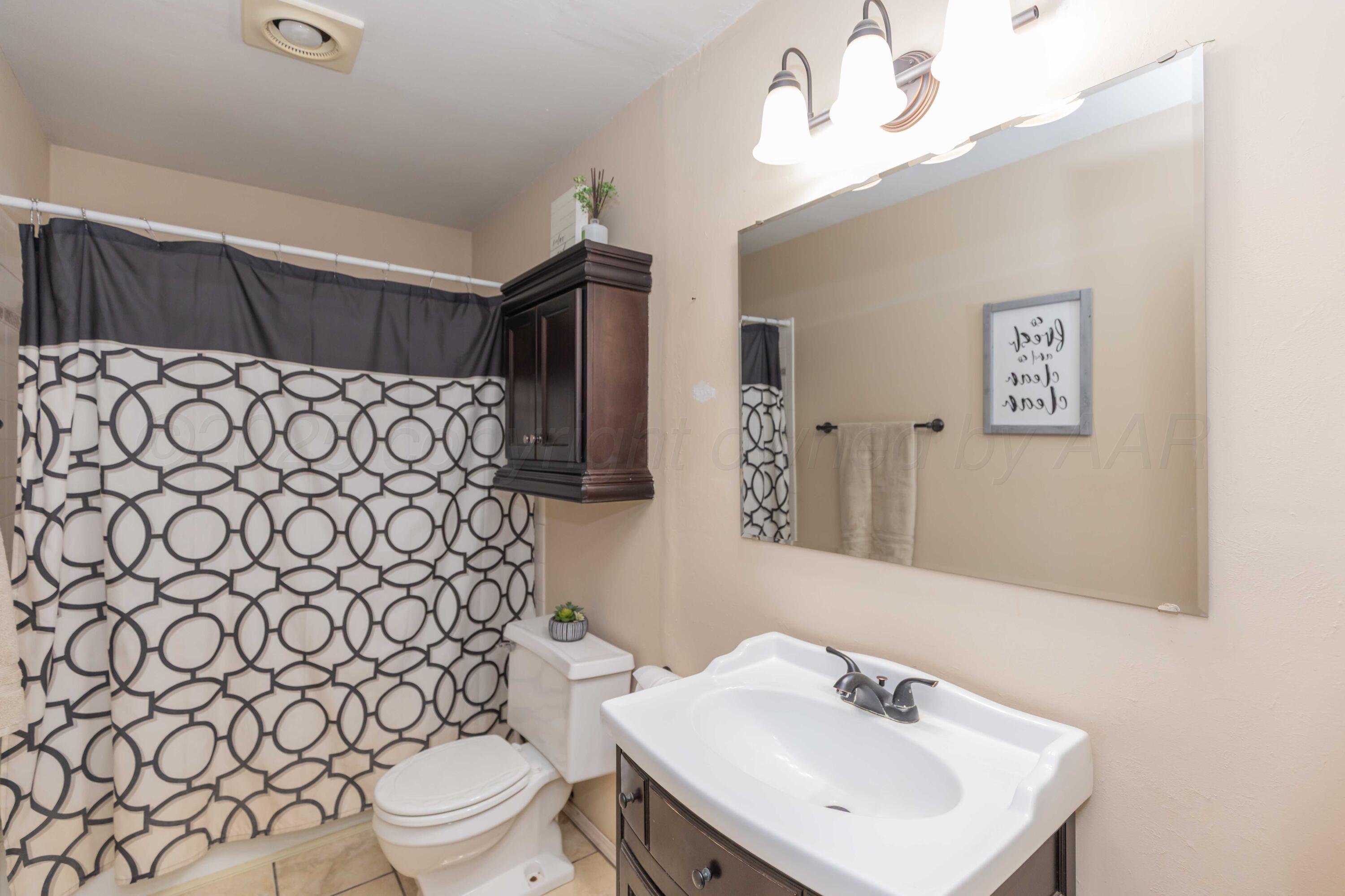 5301 Leigh Avenue Amarillo, TX 79110 - Photo 19 of 35 a bathroom with a sink mirror vanity and toilet
