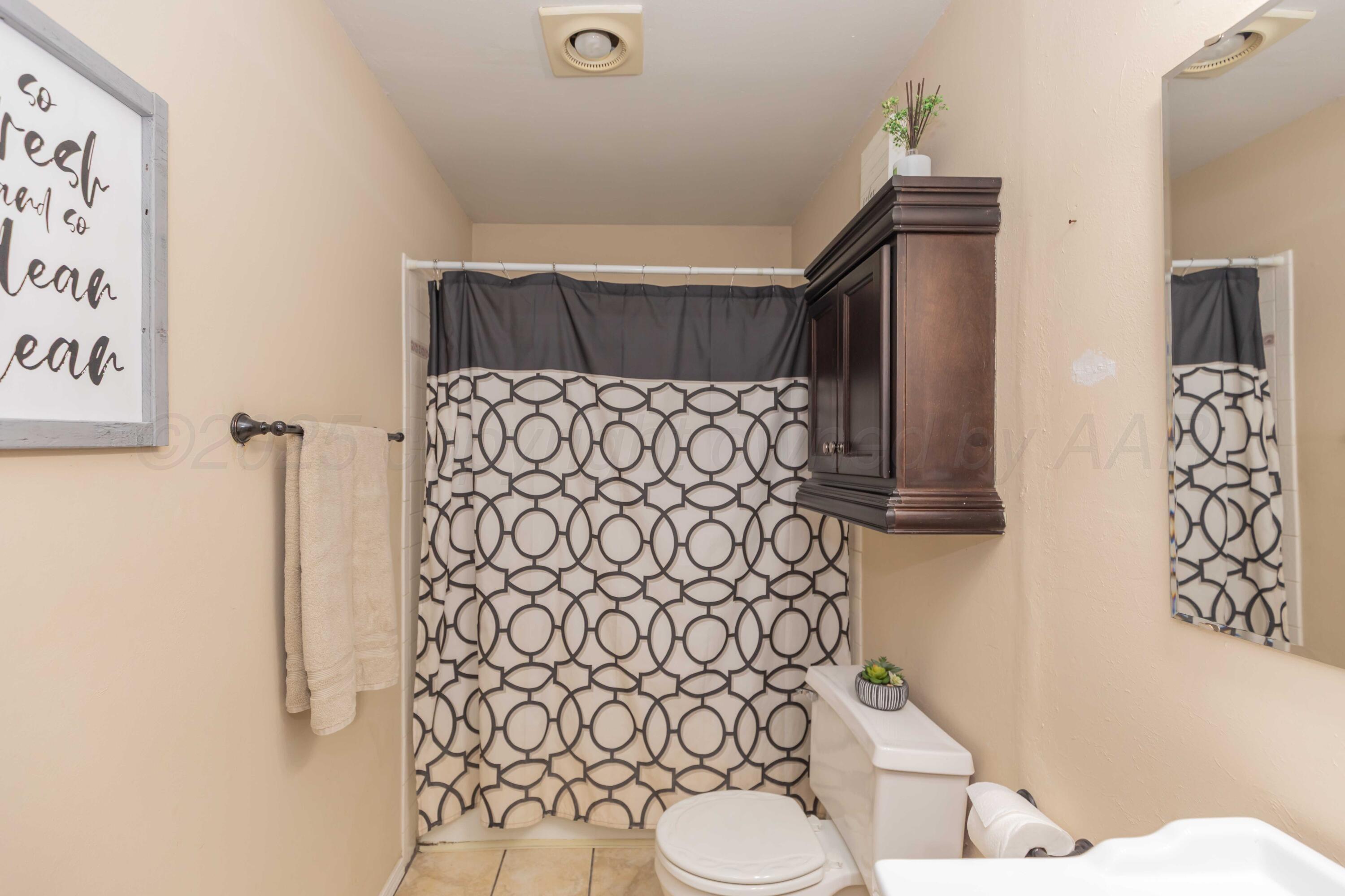 5301 Leigh Avenue Amarillo, TX 79110 - Photo 20 of 35 a bathroom with a toilet and shower curtain