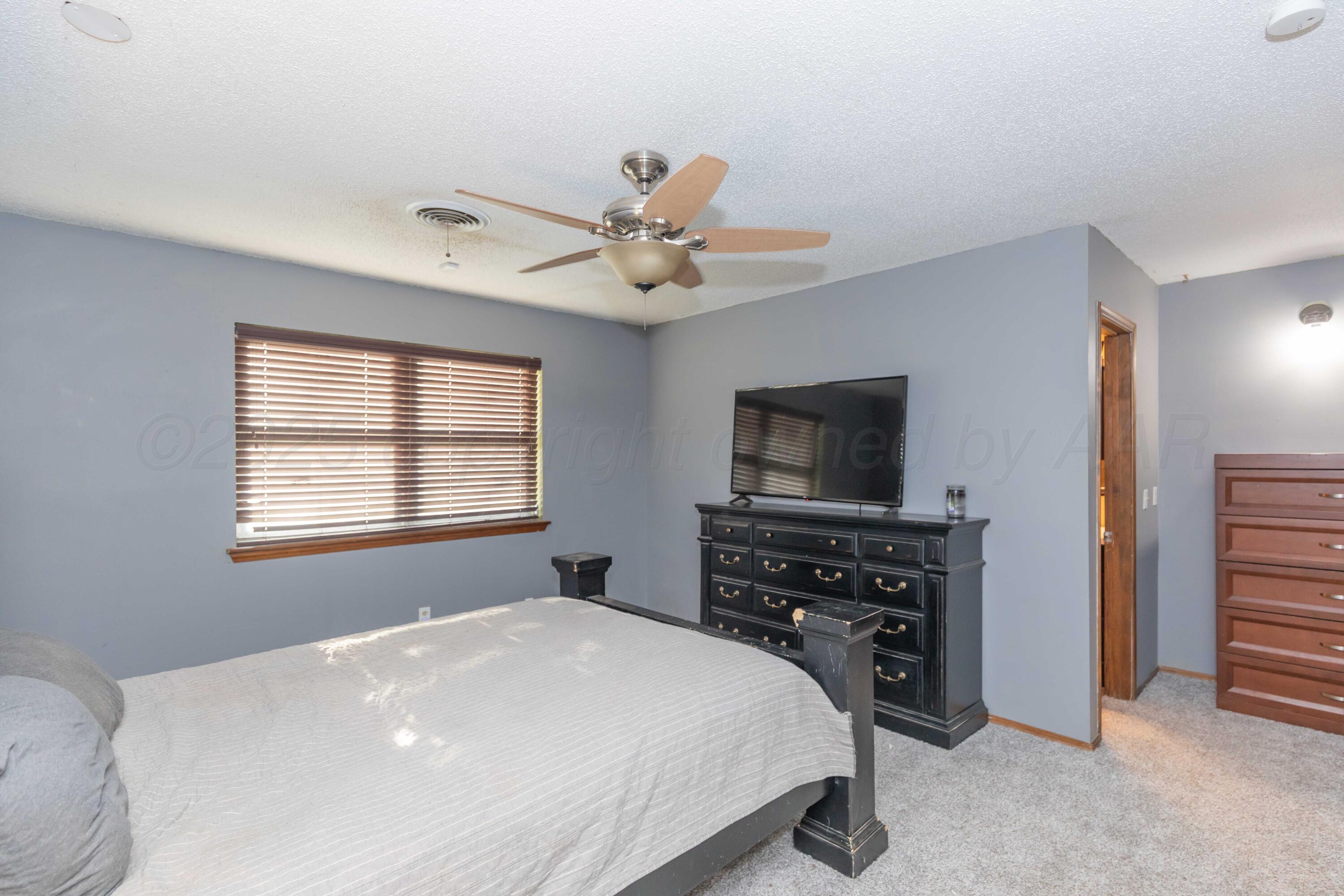 5301 Leigh Avenue Amarillo, TX 79110 - Photo 24 of 35 a bedroom with a bed and a flat screen tv