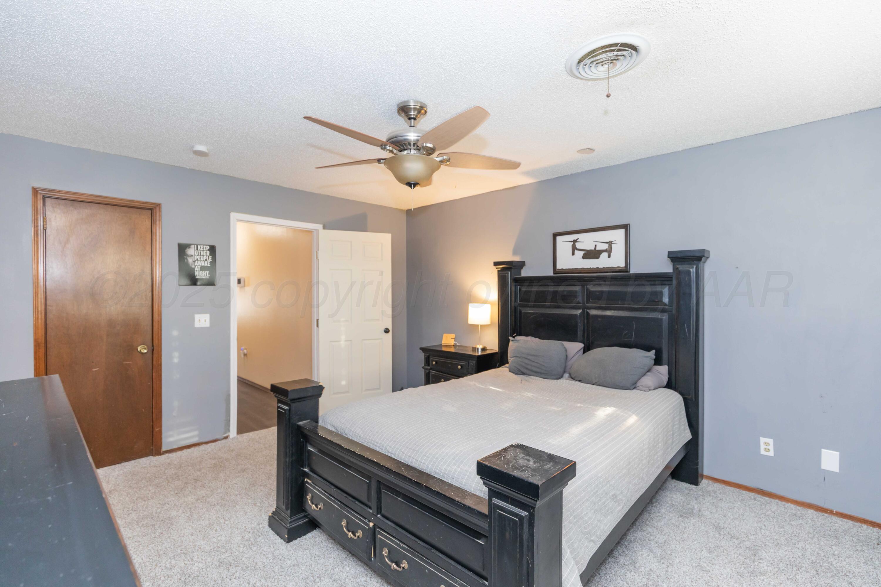 5301 Leigh Avenue Amarillo, TX 79110 - Photo 26 of 35 a bedroom with a bed and a chandelier
