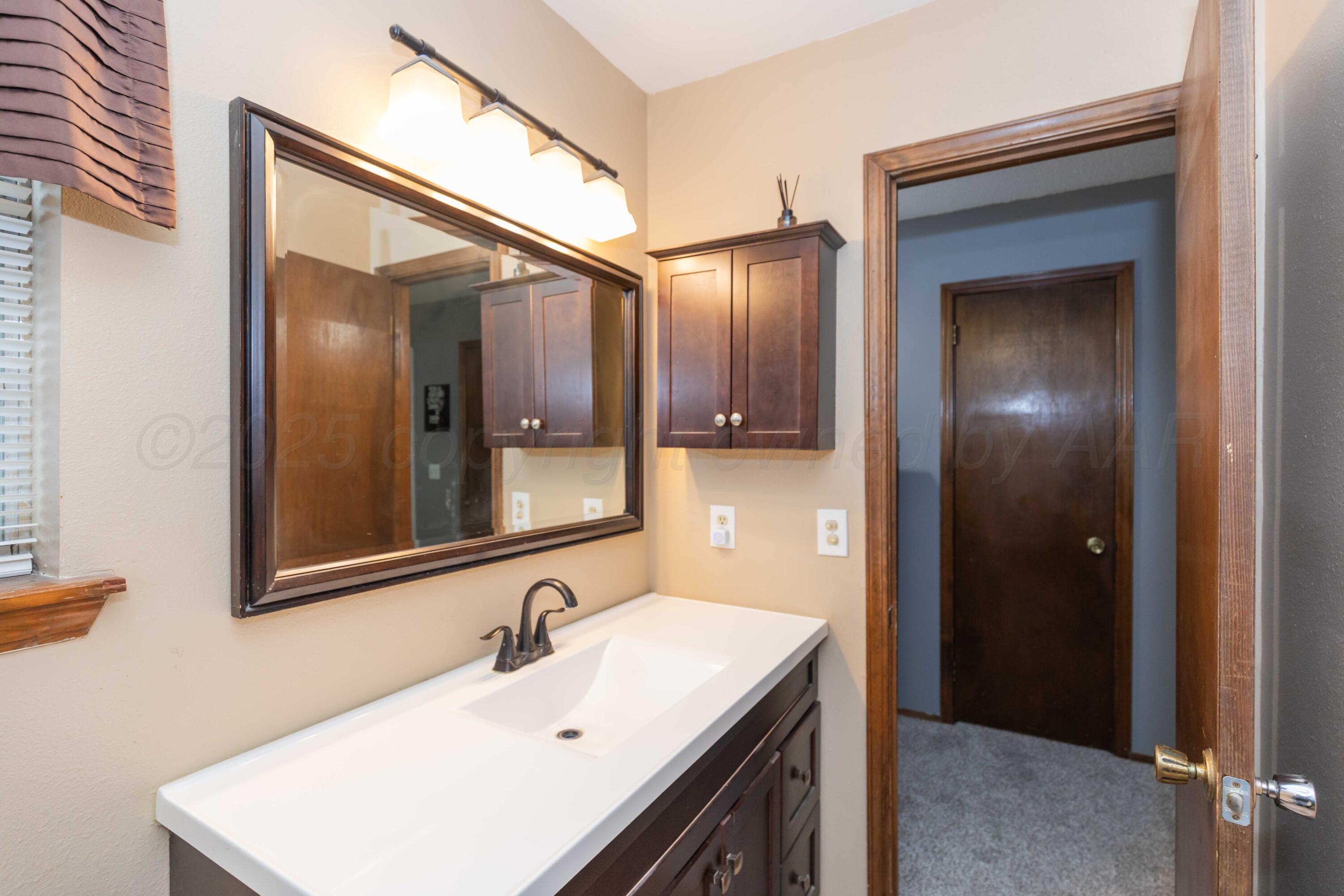 5301 Leigh Avenue Amarillo, TX 79110 - Photo 30 of 35 a bathroom with a sink and a mirror