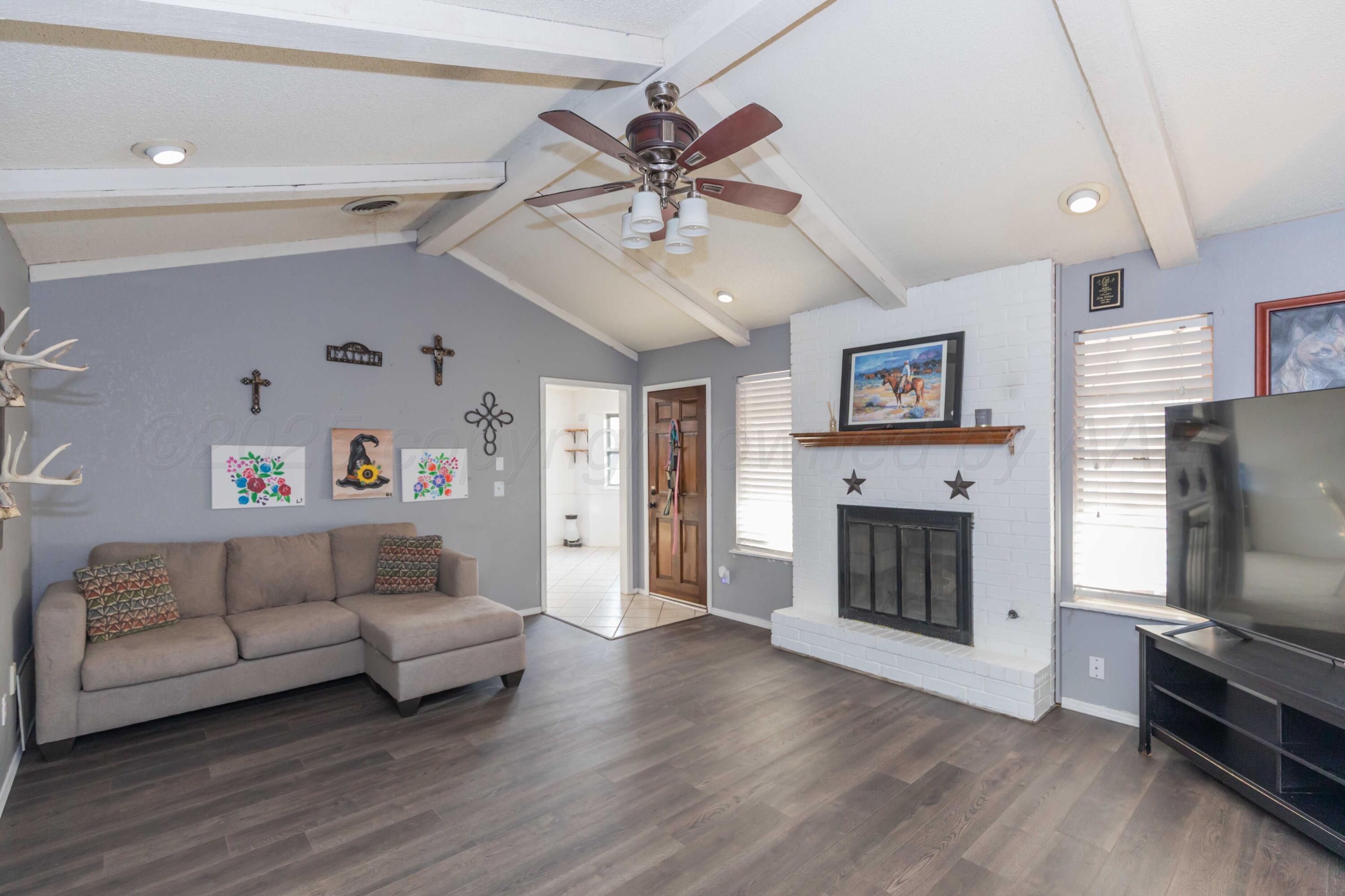 5301 Leigh Avenue Amarillo, TX 79110 - Photo 6 of 35 a living room with furniture a flat screen tv and a fireplace