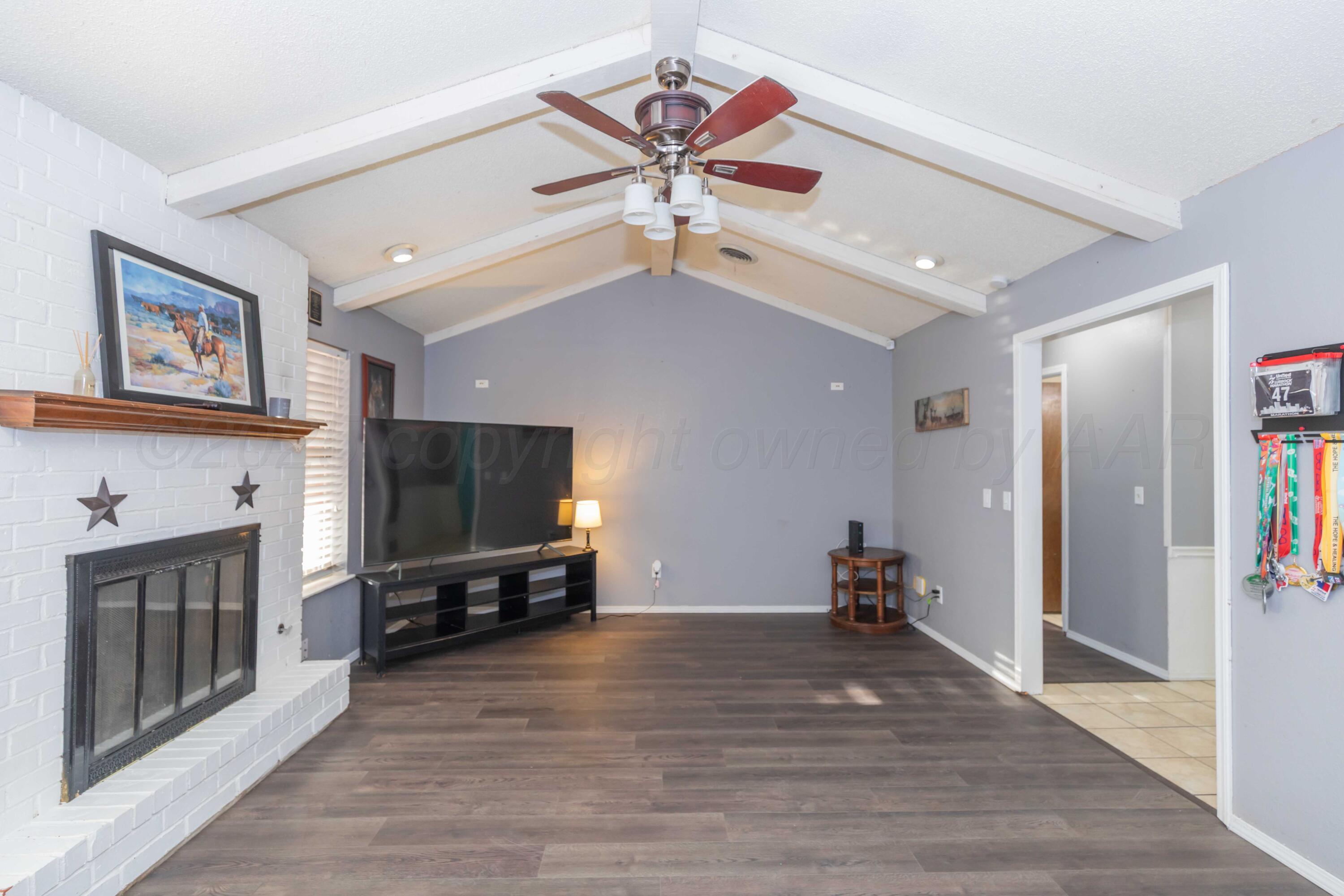 5301 Leigh Avenue Amarillo, TX 79110 - Photo 9 of 35 a living room with furniture a flat screen tv and a fireplace