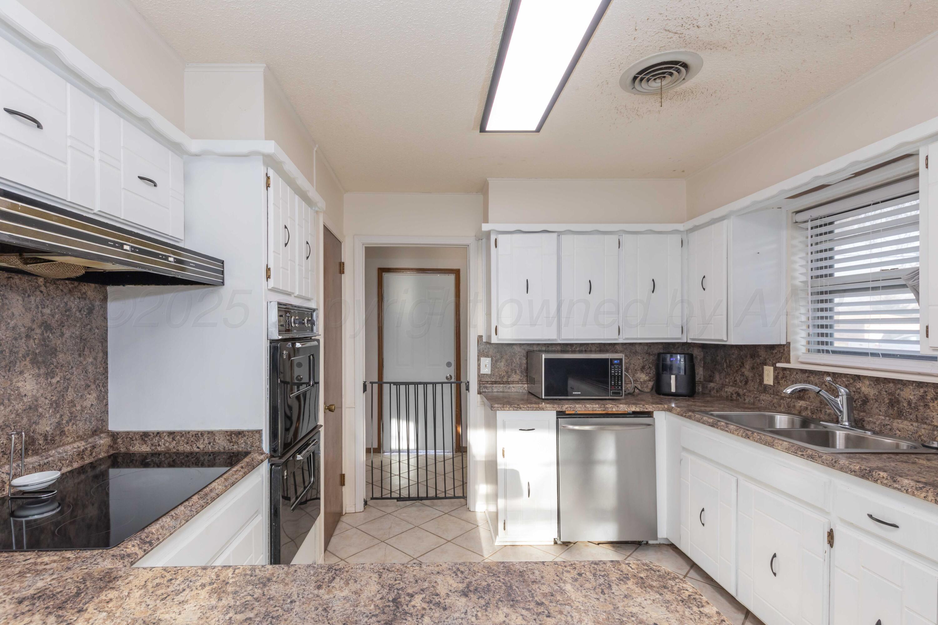 5301 Leigh Avenue Amarillo, TX 79110 - Photo 10 of 35 a kitchen with stainless steel appliances granite countertop a sink stove and refrigerator